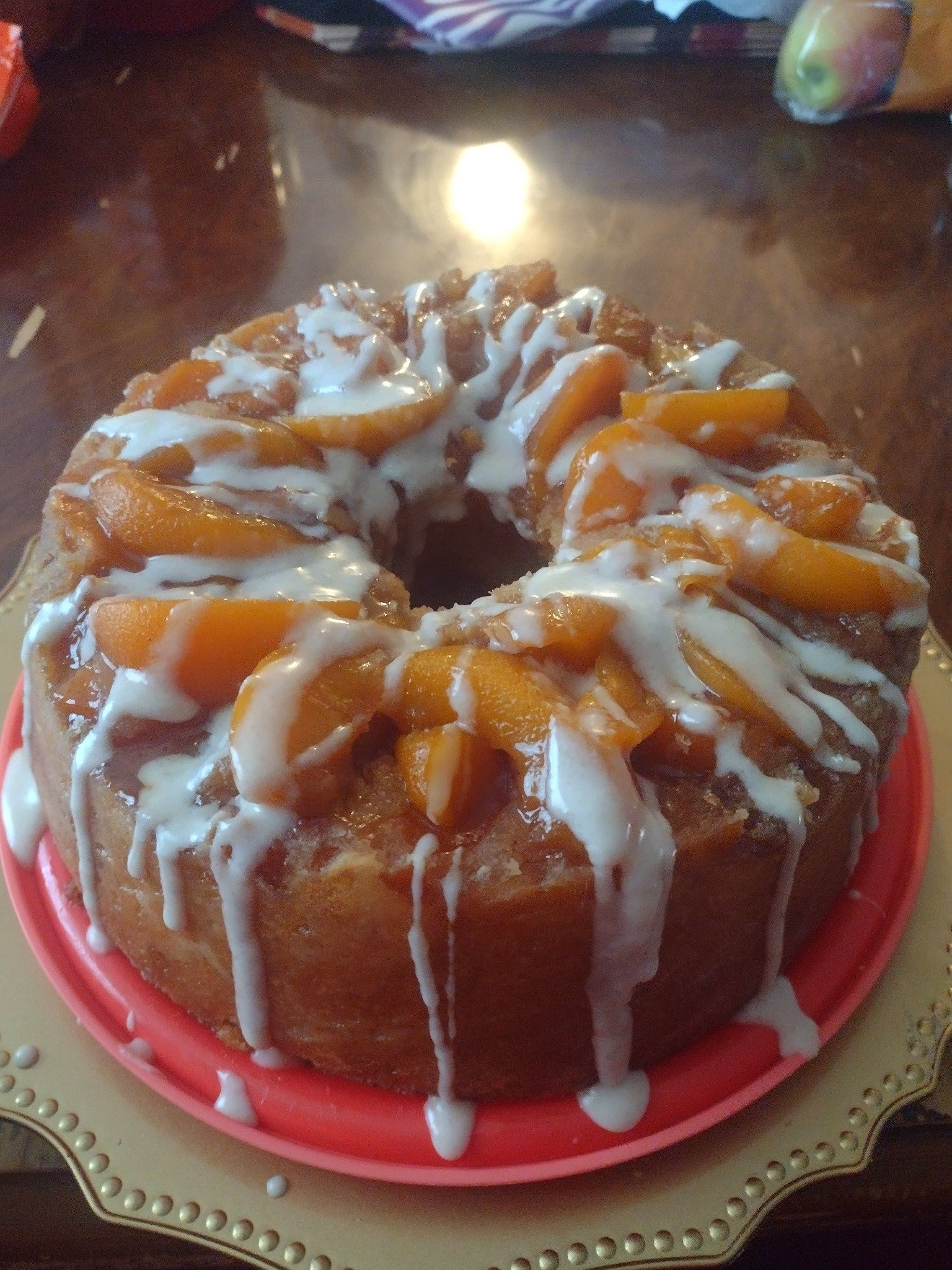 Peach Cobbler Pound Cake topped with peaches, crumble, and vanilla glaze